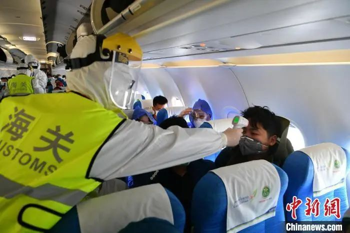  资料图：工作人员为入境旅客测量体温。刘冉阳 摄