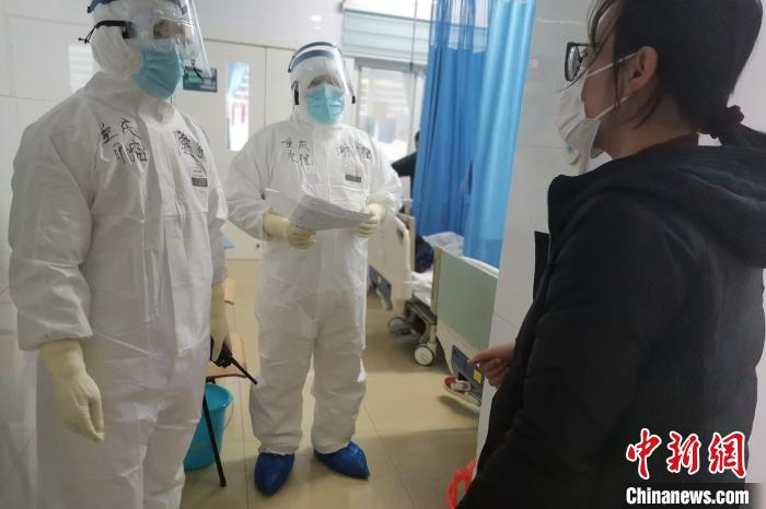     图为谢才德（中）在病区了解患者病情。重庆市委统战部供图