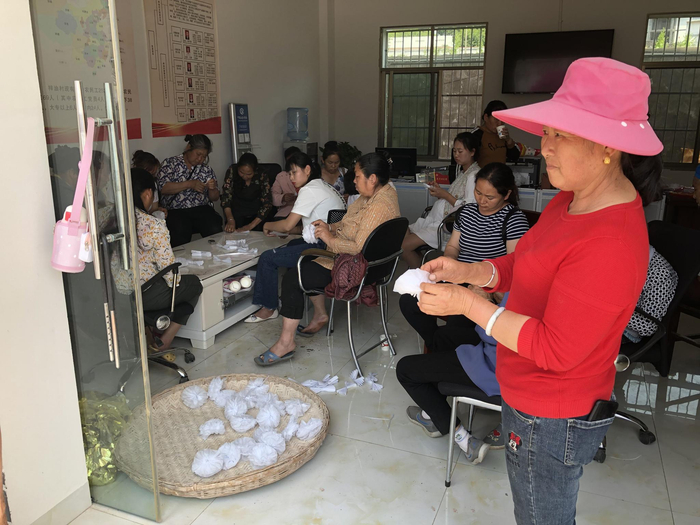 天鹤村和披砂村的村民自发聚集在梓油村村委会准备祭奠用品。新京报记者王翀鹏程 摄