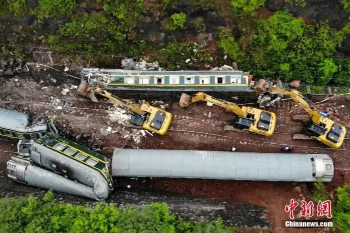 ▲挖掘机合力移动侧翻的列车。杨华峰 摄  