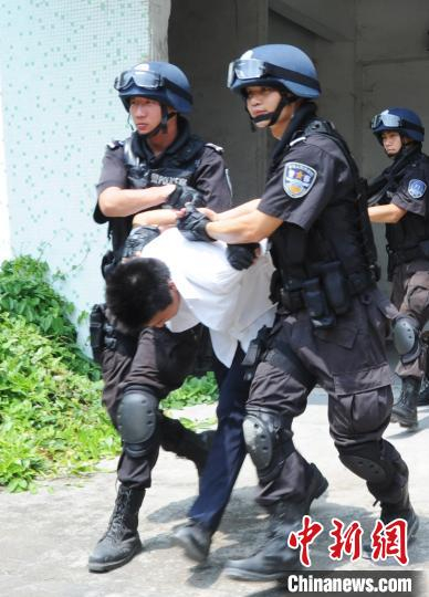 黄坤(左一)生前在搜捕现场资料图。警方供图