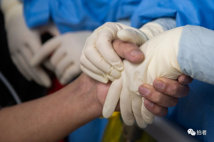 △ 3月30日晚，武汉协和医院西院区，患者握住北京医疗队队员的手，不舍告别。