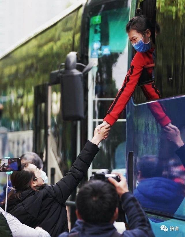 △ 3月31日上午，武汉，临别前，医疗队员与武汉市民握手告别。