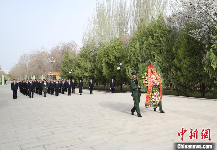 礼兵手抬花篮，缓步走向王震将军铜像前。　杜京京 摄