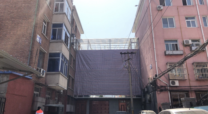 昌平区北怀里小区18号楼与19号楼之间的房屋安装了玻璃幕墙，目前该玻璃幕墙已被苫布遮盖。摄影/新京报记者&nbsp;罗晓静