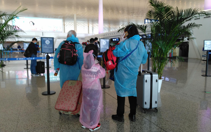  4月8日，武汉天河机场内，一家三口乘客穿着雨衣作为防护。新京报记者 海阳 摄