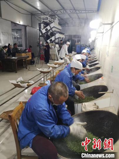图为当地农户在进行手工炒茶。　袁超 摄