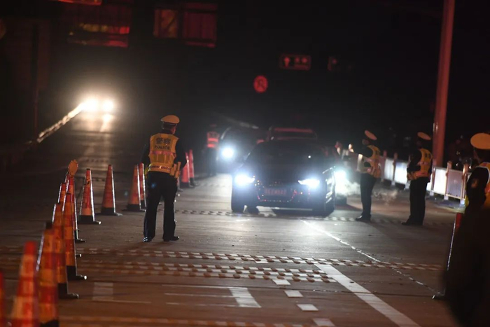 ▲4月8日零时后，京港澳高速武汉西收费站，交警指挥排队离汉的车辆。摄影/李子云