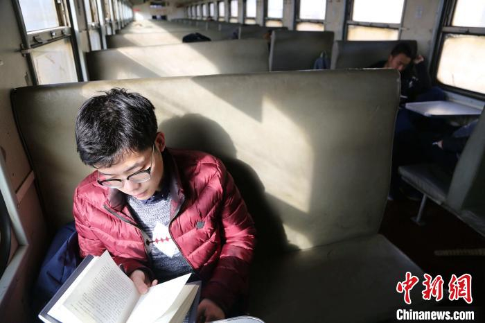 资料图：乘客在淄博至泰山7053/7054次绿皮火车内阅读。　沙见龙 摄