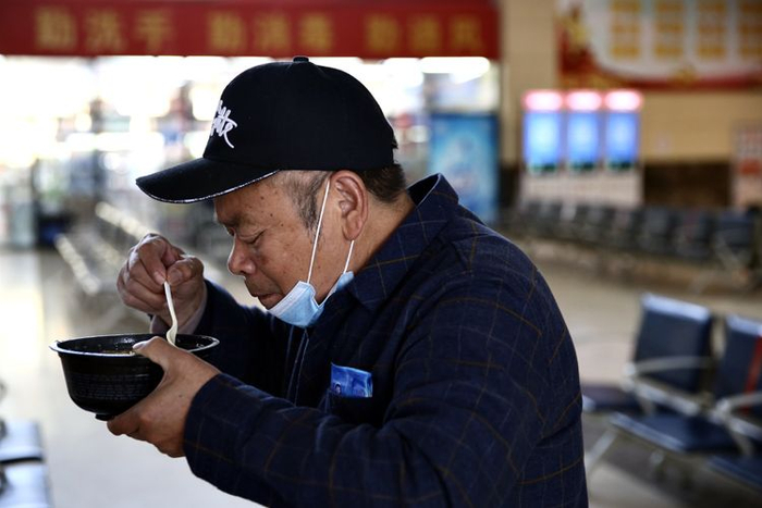  等车的旅客正吃泡面。