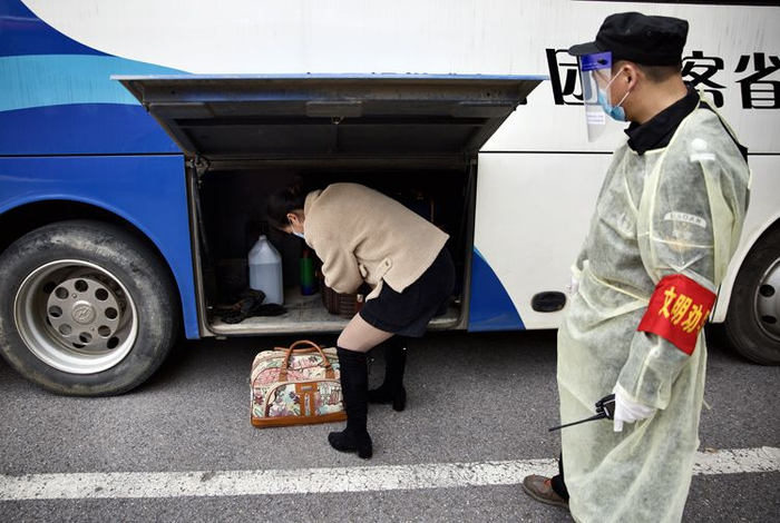  长途客车的安保人员全程监督旅客保持距离、戴口罩。