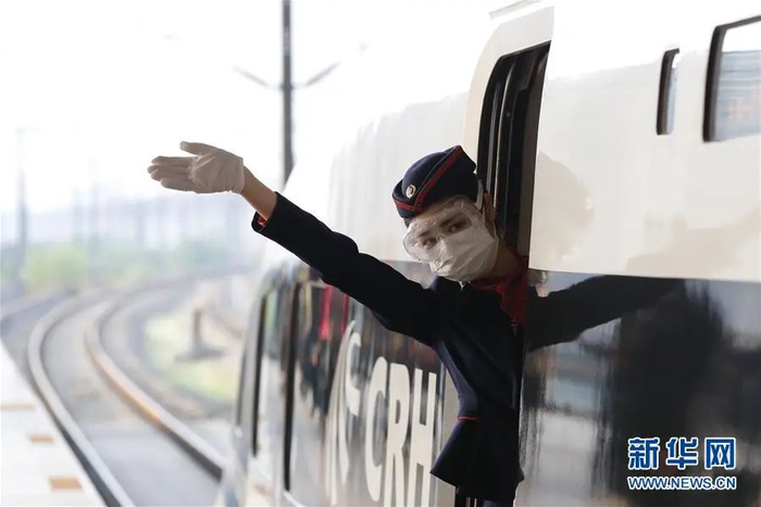 ▲4月8日，在武汉站，G431次列车乘务员在发车前向乘客挥手。当日，G431次列车由武汉站始发开往南宁东站。这是武汉市正式解除离汉离鄂通道管控措施后开往湖北省外的首趟始发列车。（&nbsp;新华社记者 沈伯韩 摄）