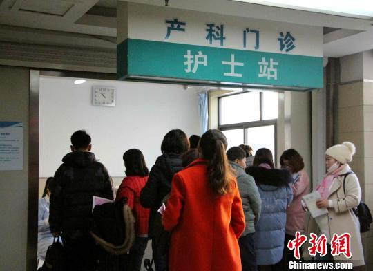 资料图：孕妇在家属的陪同下，在产科门诊前排队测量血压。　赵晓 摄