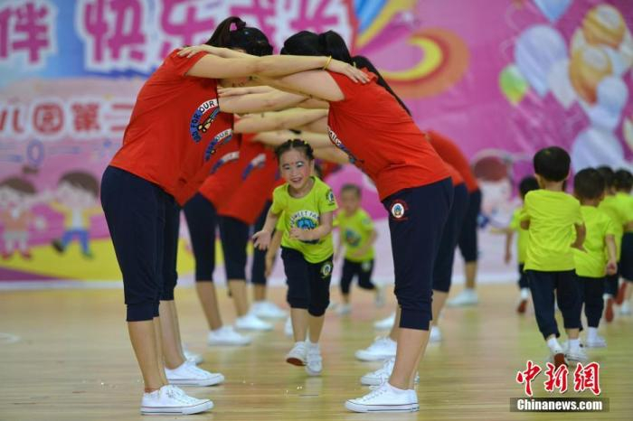 资料图：广西桂林市龙胜各族自治县民族体育馆，孩子们和家长在表演亲子操。中新社记者 潘志祥 摄