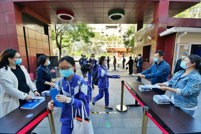 老师把学校制作《初三开学学生手册》第一时间送到学生手中。