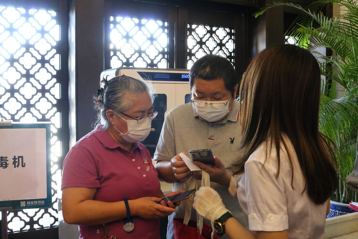 国图工作人员现场帮助读者通过系统预约借书。刘曼曼 摄