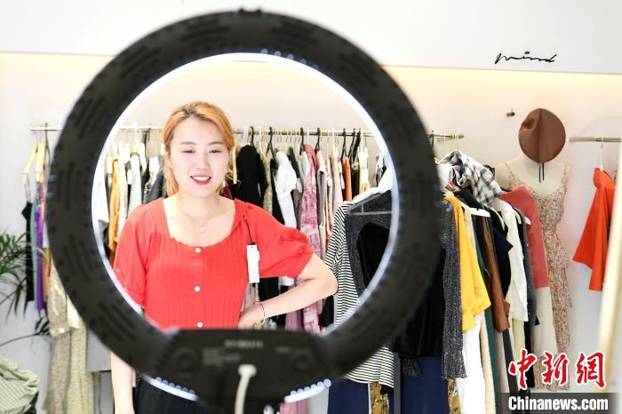主播吴悦正在向直播间的粉丝们介绍店里新上的一批夏装。　韩苏原 摄