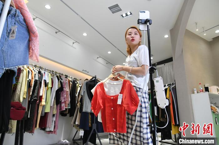 主播吴悦正在向直播间的粉丝们介绍店里新上的一批夏装。　韩苏原 摄