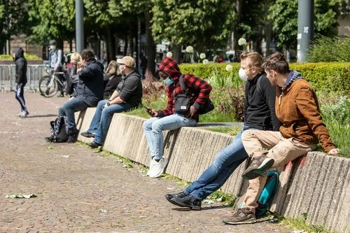 ▲5月11日，在法国北部城市里尔，人们在路边晒太阳。新华社发