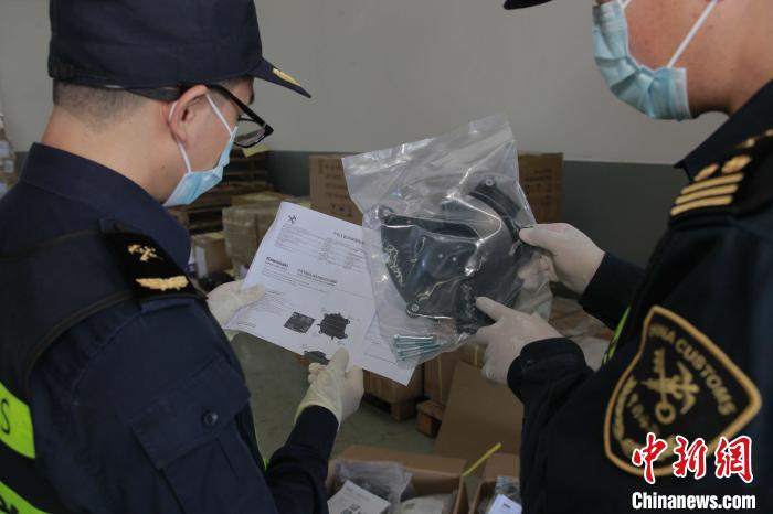 拱北海关关员对查获的侵权摩托车配件进行查验。    林昌锋 摄
