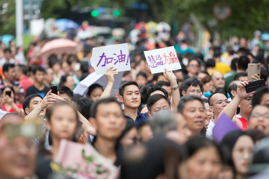 家长举牌等待参加高考的孩子。