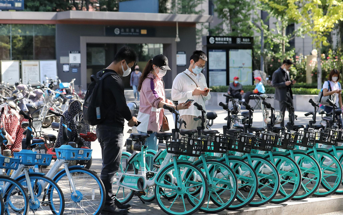 北京地铁7号线达官营站B口外，市民换骑共享单车。新京报记者 王贵彬 摄