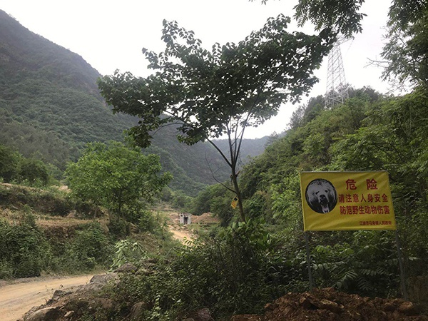 事发地不远处的路口，挂起了一块警示牌，有民警在此值守 澎湃新闻记者 何利权 图