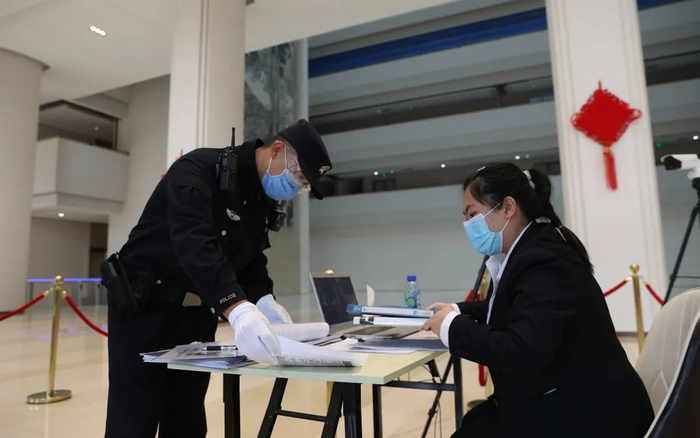 ▲5月7日，王晓波在检查商业楼宇内人员出入记录。新京报记者 王飞 摄