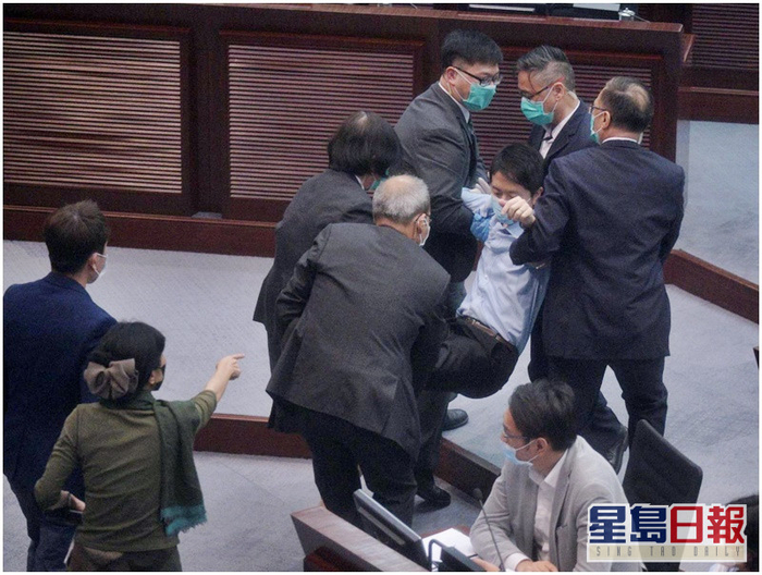 会议过程中，多名反对派议员被驱逐并被抬离会场 图自《星岛日报》