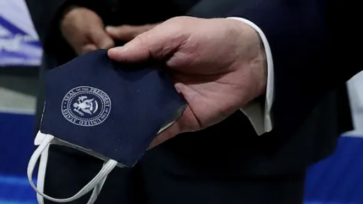 “定制款”口罩上印有总统徽章。/《卫报》视频截图