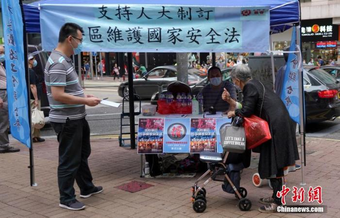 一位长者签名后竖起大拇指支持立法。中新社记者 张炜 摄