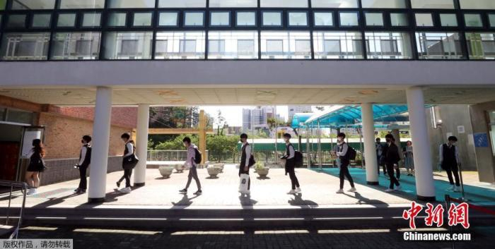 资料图：韩国蔚山，学生排队等待体温检测。