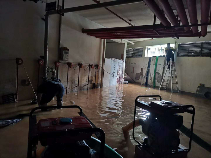 事发后，业主们自发对地下车库进行排水。图片来源 受访者供图