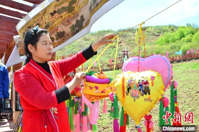 图为河湟刺绣省级非物质文化遗产代表性传承人俞兰展示刺绣香包。　鲁丹阳 摄