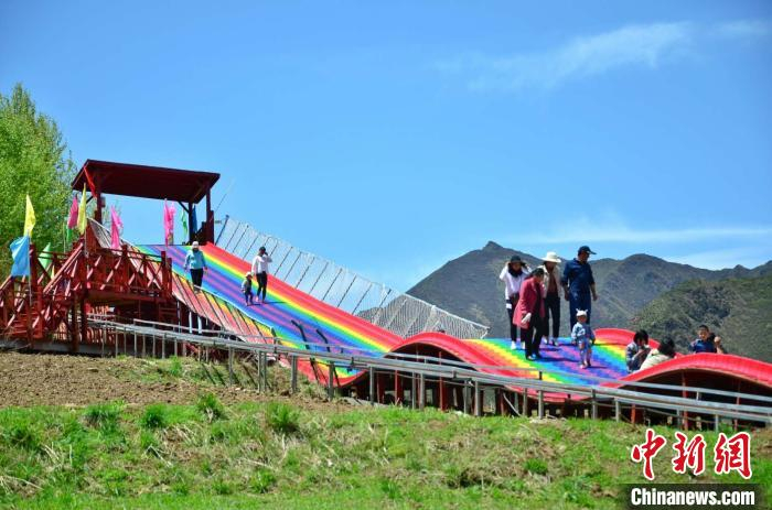 图为游客在石碑瑞丰花海度假村的彩虹滑道上游玩。　鲁丹阳 摄