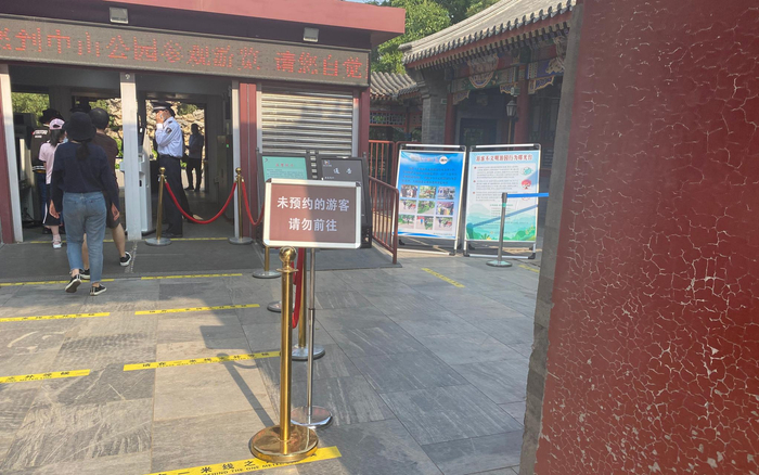 中山公园门口设立了提示牌，提醒游客提前预约进园。摄影/新京报记者 应悦