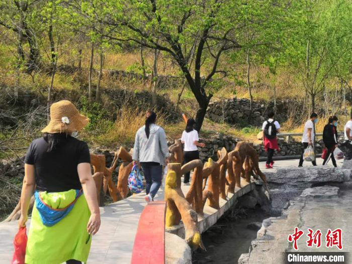 游客穿越唐县潭瀑峡景区小石桥。　唐县文化和旅游局供图 摄