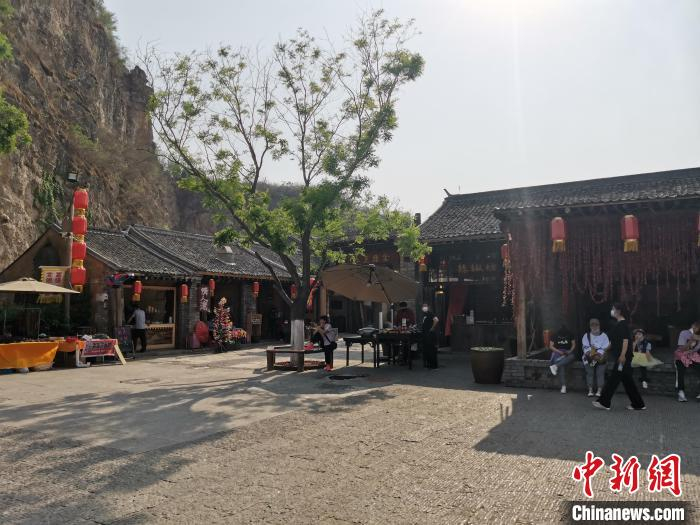 游客在“恋乡？太行水镇”景区休闲水街小憩。　张涛 摄