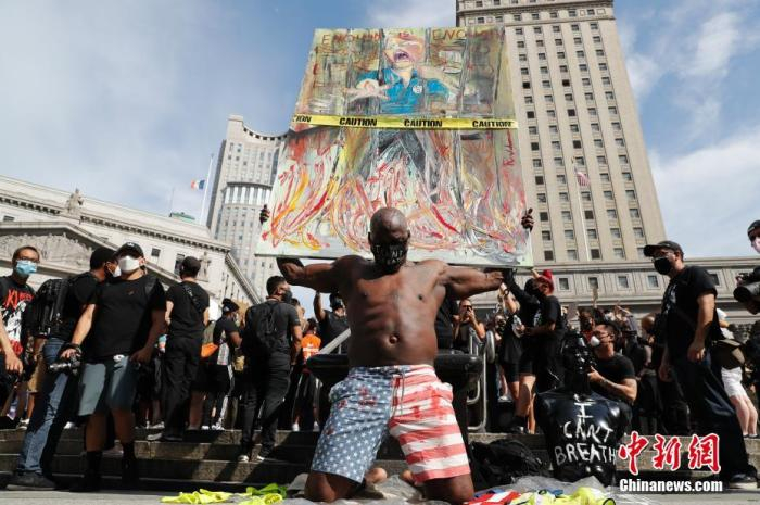 　　当地时间5月29日，纽约上千民众聚集在曼哈顿佛利广场抗议。图为一名男子利用画作抗议。中新社记者 廖攀 摄
