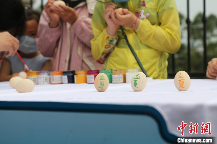 图为小朋友在鸡蛋上写上“立夏”字样。　杨孝永 摄