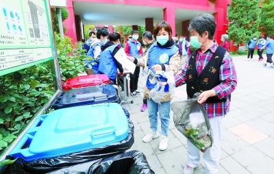  5月4日，八里庄街道青年志愿者向社区居民讲解垃圾分类知识，协助大家进行垃圾分类投放。饶强/摄