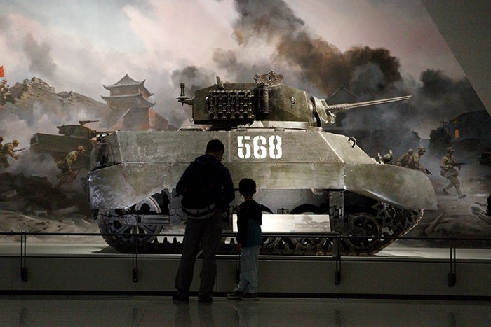 观众参观美国造M3A3斯图亚特轻型坦克。1948年，该坦克参加济南战役，炮手沈许勇敢作战，出色完成任务，为此，沈许被誉为“铁人”英雄，该坦克被授予“功勋坦克”称号。