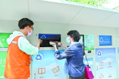 &nbsp;&nbsp;&nbsp;&nbsp;▲垃圾分类指导员手把手地教居民使用智能回收箱。周文玥摄&nbsp;&nbsp;