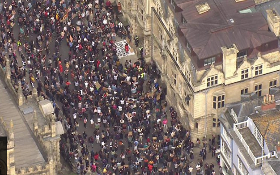 牛津大学奥里尔学院外示威者要求拆除塞西尔·罗兹的纪念碑。/BBC视频截图