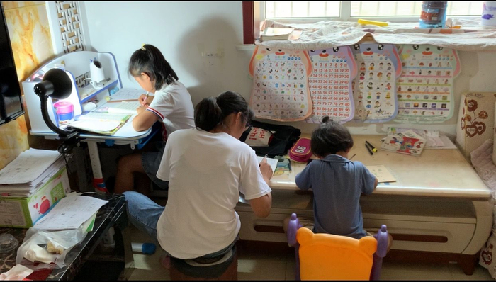 6月11日，陈春秀在家辅导孩子做作业。新京报记者王瑞文摄