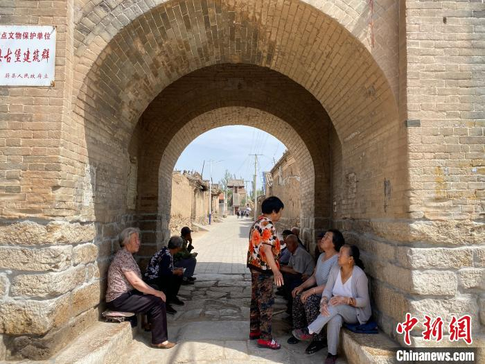 图为当地村民在小饮马泉村古堡纳凉。　黄歆尧 摄