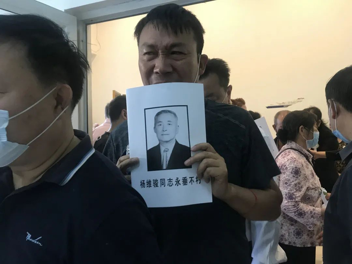  杨维骏的追悼会上，人们举着他的遗像含泪告别。新京报记者&nbsp;王昱倩 摄