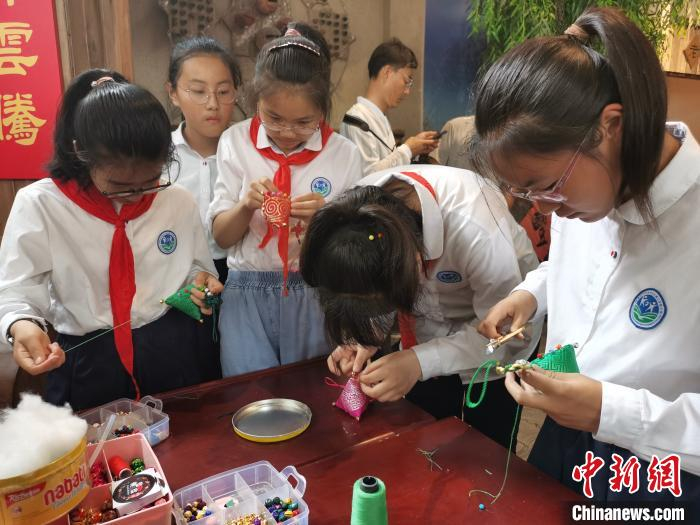 当地的学生利用休闲时间制作传统的香囊作为村里的旅游纪念品。　钟升 摄