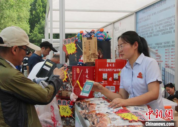 在非遗购物节上，市民下单购买非遗产品。(资料图) 赵晓 摄