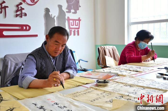 图为退休职工在华隆路社区内练习书法。　鲁丹阳 摄